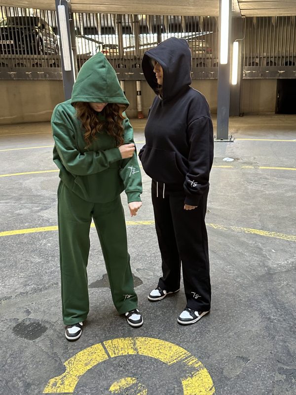 This is an image of two ladies wearing Plain Dark Green Hoodie | Grön Hoodie | Unisex​ and Plain Black Hoodie | Svart Hoodie | Unisex​