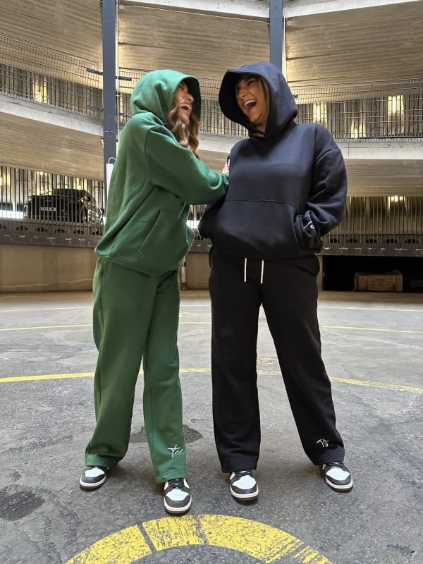 This is an image of two ladies wearing Plain Dark Green Hoodie | Grön Hoodie | Unisex​ and Plain Black Hoodie | Svart Hoodie | Unisex​