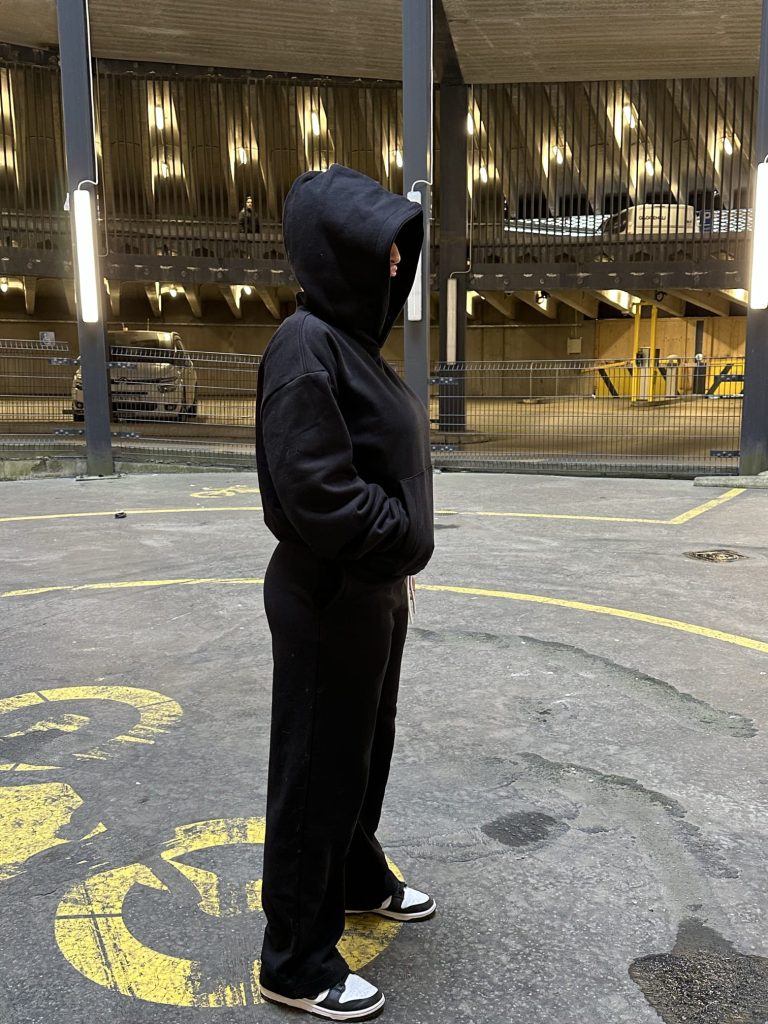 This is an image of a lady wearing Plain Black Hoodie | Svart Hoodie | Unisex​